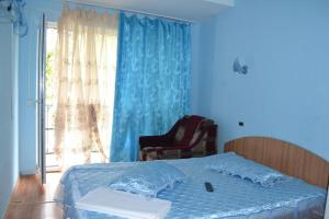 une chambre avec un lit, une chaise et une fenêtre dans l'établissement Vila Denisa, à Eforie Nord 5 autres photos