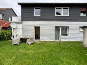 a house with two chairs and a table in the yard at International 8 in Bad Harzburg