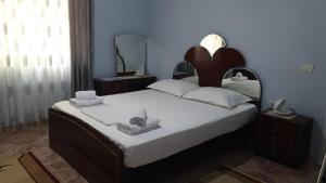 a bedroom with a large bed with towels on it at Green Forest in Berat