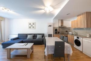een woonkamer met een blauwe bank en een tafel bij Apartamento EL RIU en Arinsal in Arinsal
