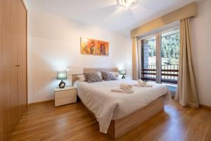 sypialnia z dużym łóżkiem i oknem w obiekcie Apartamento EL RIU en Arinsal w mieście Arinsal