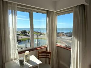 a room with a table and a view of the ocean at Hotel Guerrero in Mar del Plata