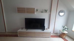 einen Flachbild-TV auf einem Stand in einem Wohnzimmer in der Unterkunft Miramar in Viveiro