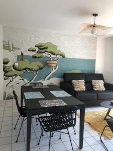 a living room with a table and a couch at Maison de ville proche mer in Les Sables-d'Olonne