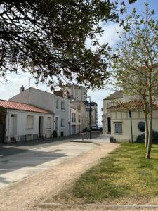 eine Straße in einer Stadt mit Gebäuden und einem Baum in der Unterkunft Maison de ville proche mer in Les Sables-dʼOlonne