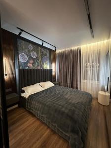 a bedroom with a large bed and a window at Auezov City in Almaty