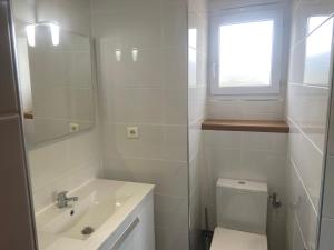 uma casa de banho com um lavatório, um WC e uma janela. em Residence Les Jardins de Sainte-Lucie "Piscine chauffée" em Sainte-Lucie de Porto-Vecchio