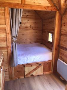 a bedroom in a log cabin with a bed in it at Domaine Rosfelder - locations de gîte et cabane insolite in Gertwiller