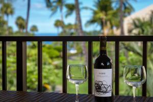 a bottle of wine and two glasses on a table at Kamaole Sands 5-316 in Wailea