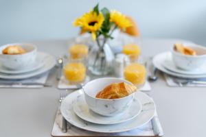 Una mesa cubierta con tazas de café y un tazón de croissants. en The Blue Barbican Flat- spacious, stylish, in a perfect location and accessible, en Plymouth 12 fotos más