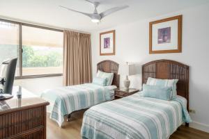 a bedroom with two beds and a window at Kamaole Sands 5-316 in Wailea +38 photos