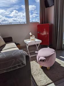 Gîte Chez Toinette في ساينليجيي: غرفة نوم مع سرير وطاولة مع كرسي قدم خنزير