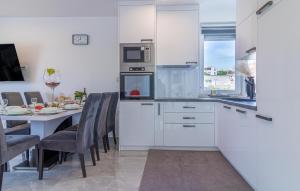 a kitchen with white cabinets and a table with chairs at 4 Bedroom Lovely Home In Liznjan in Ližnjan +37 photos