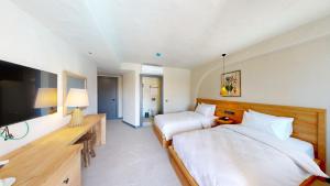 1 dormitorio con 2 camas y TV de pantalla plana en Unsal Hotel en Oludeniz
