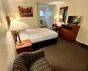 una camera d'albergo con letto e sedia di North Colony Motel and Cottages a Bartlett