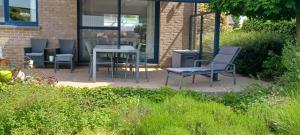 un patio con sillas y una mesa en didi logement en Westerlo