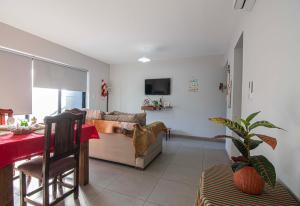 a living room with a couch and a table at Departamento del Bosque equipado para 4 patio parrilla cochera cubierta in Maipú