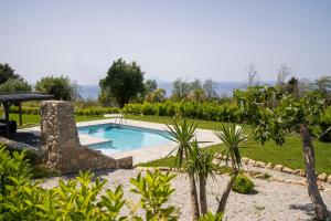 una piscina en un jardín con árboles y arbustos en Alle Preziose Dimore, en Tropea