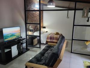 uma sala de estar com um sofá, uma cama e uma televisão em Departamento Porá em Puerto Iguazú