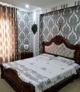 a bedroom with a large bed in a room with wallpaper at Chaqar in Tashkent