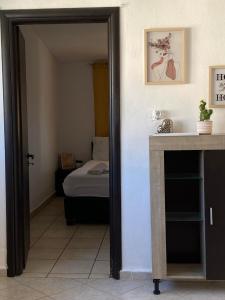 Habitación con cama y puerta que conduce a un dormitorio. en Popi's Apartment, en Goníai
