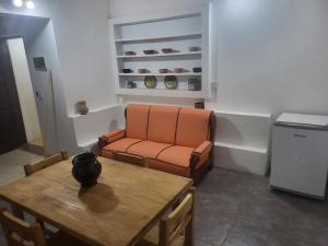 an orange chair and a table in a room at Departamento Porá in Puerto Iguazú