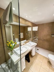 een badkamer met 2 wastafels en een toilet bij Hotel Marina in Roses