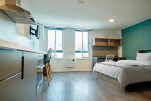 a hotel room with a bed and a desk at Studios and Private Bedrooms with Shared Kitchen at Canvas Bristol near the City Centre in Bristol