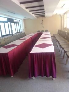 a long table in an empty room with chairs at TROTTERS B&B KENOL in Gitura