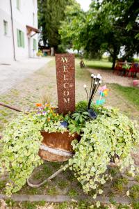 um jardim com um cartaz e flores num plantador em Tenuta EnGi em Verona