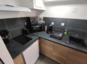 a small kitchen with a sink and a microwave at Studio proche centre-ville in Dax