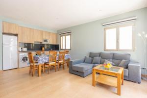 a living room with a couch and a table at Bosset Platja in Can Picafort