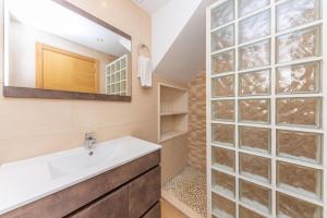 a bathroom with a sink and a glass wall at Bosset Platja in Can Picafort +27 photos
