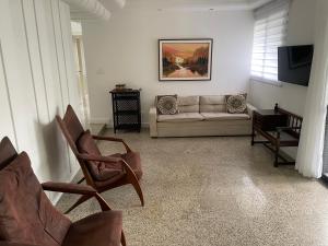 a living room with a couch and a tv at Conforto e localização privilegiada na Pituba in Salvador