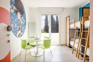 Habitación con mesa, sillas y litera en Ostello della Gioventù Brindisi, en Brindisi
