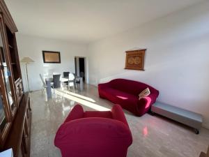 a living room with a red couch and a table at Venice Homes & Holidays in Venice