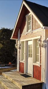 カラヨキにあるIdyllinen mökki ja pihasauna jokirannassa - sisältää liinavaatteet ja loppusiivouksenの小さな木造家屋(ドア、ポーチ付)