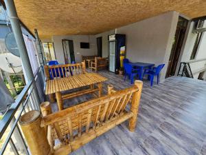 un portico con panca in legno, tavolo e sedie di Guest House Gio a Kobuleti