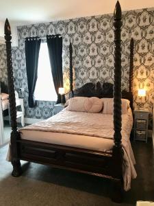Norman Guest House with Free Parking في ويتبي: غرفة نوم بسرير كبير مع مظلة