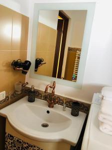 y baño con lavabo y espejo. en Muresenilor Residence, en Brasov