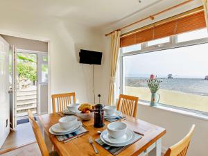 a dining room with a table with a view of the ocean at 2 bed in Porthallow LPEBB in Porthallow