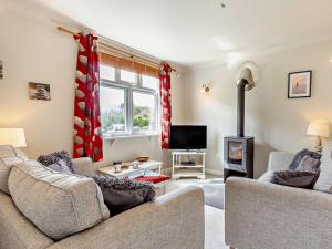 a living room with a couch and a fireplace at 2 bed in Porthallow LPEBB in Porthallow