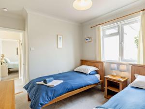 a bedroom with two beds and a window at 2 bed in Porthallow LPEBB in Porthallow