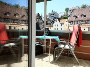 una mesa y sillas en un balcón con vistas a los edificios en Ferienwohnung Langhammer, en Schonungen