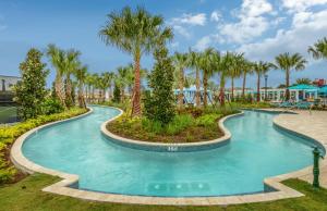 a swimming pool at a resort with palm trees at Large Villa wPrivate Pool Game Room Waterpark in Kissimmee