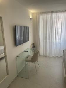 a living room with a glass table and a television at Amalfi Suite Boutique Hotel in Amalfi