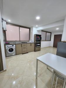 sala de estar amplia con mesa y cocina en Appartements climatisés JANYA HOLIDAYS, en Alhucemas