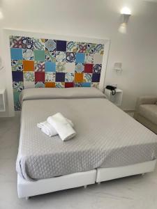 a white bed with two towels on it in a bedroom at Amalfi Suite Boutique Hotel in Amalfi