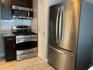 a kitchen with a stainless steel refrigerator and a stove at Peace of Cleveland 2bdrm Plus Semi Private Study with Futon 1st Floor Apartment Pets Welcomed, Family Friendly in Cleveland
