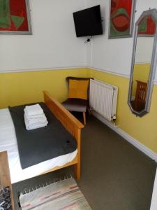 Habitación pequeña con cama y espejo. en Masons Arms, en York